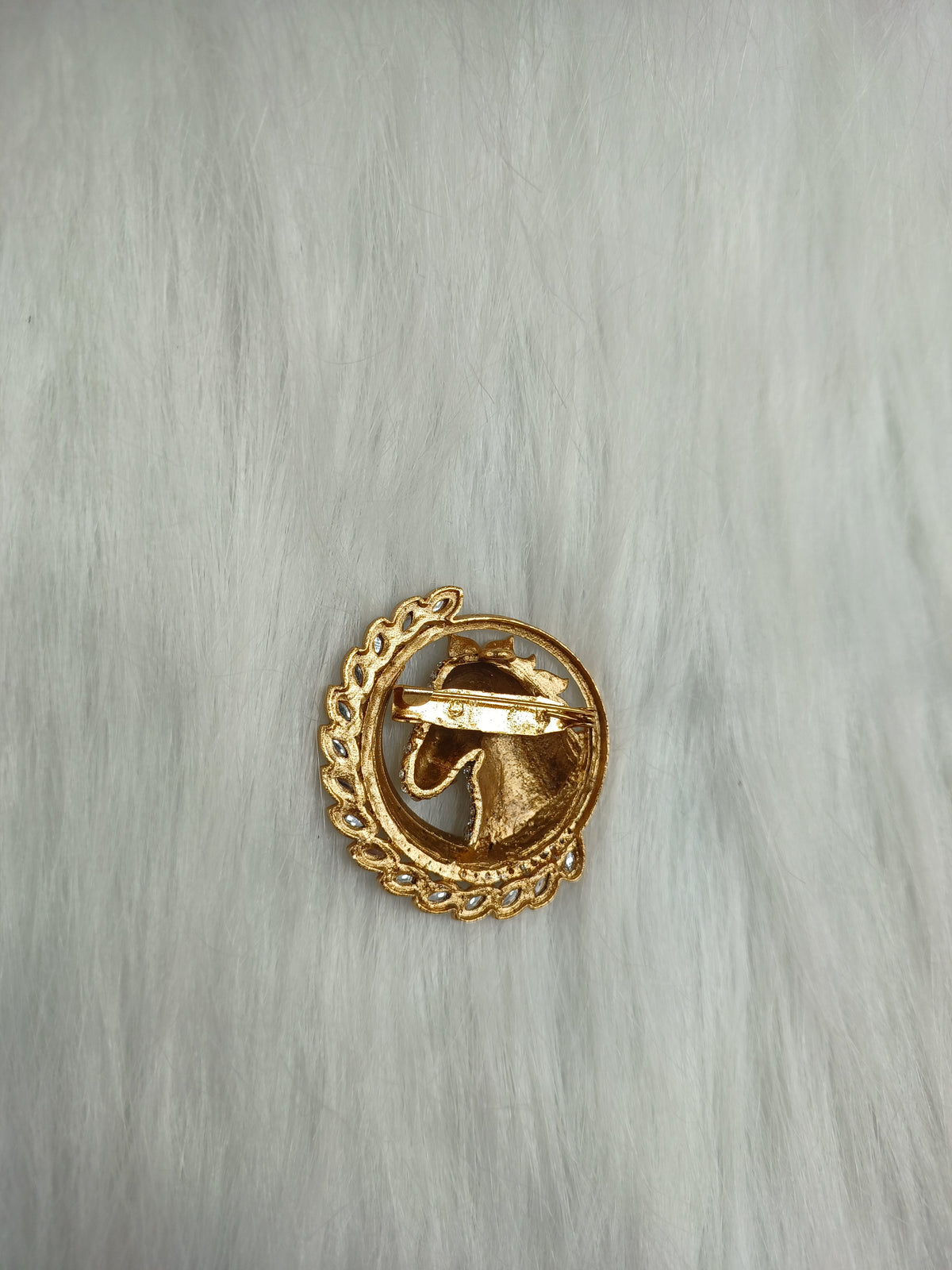 Golden metal and stonework horse brooch with intricate details, showcasing elegant craftsmanship and a luxurious design.