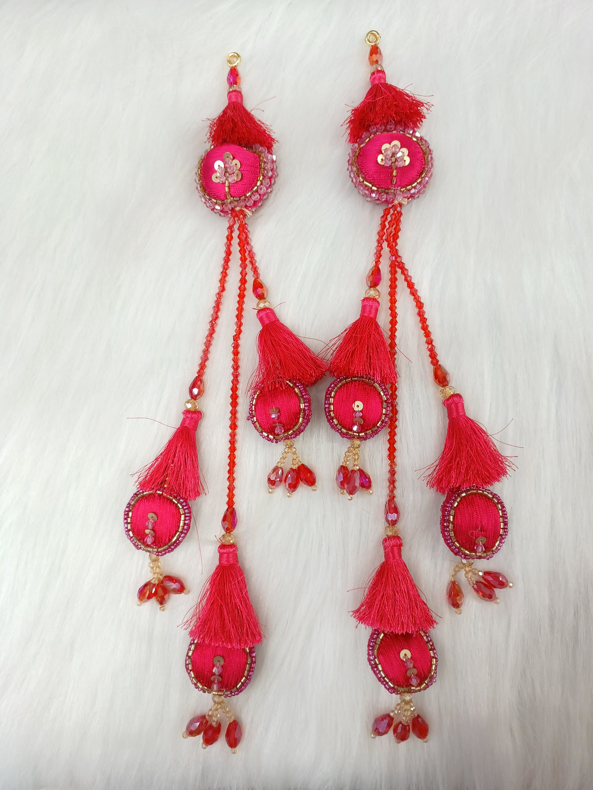 Reddish pink lehenga with cutdana and crystal handwork, featuring decorative latkan details, detailed embroidery by Lace Hut.