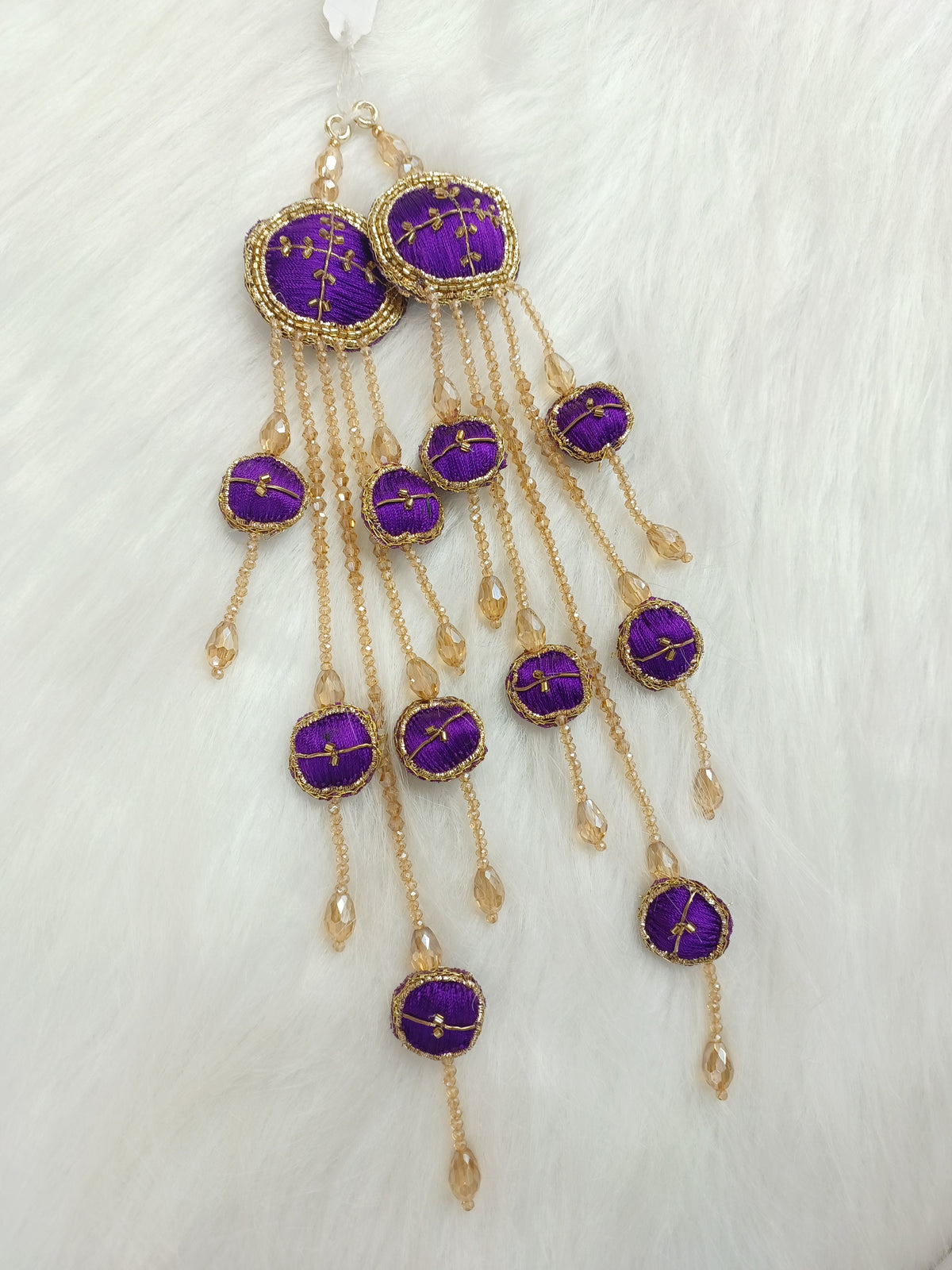 Purple Zardosi, cutdana, and crystal handwork lehenga with latkan detailing, showcasing intricate embroidery and vibrant fabric.