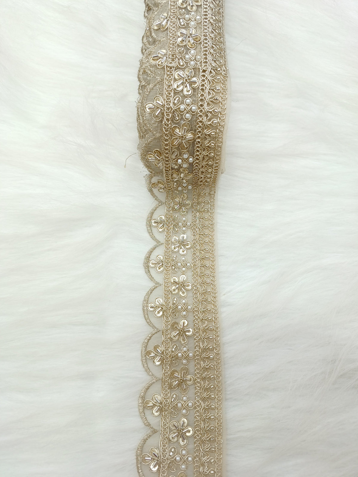 Gold lace with scallop water motifs featuring cutdana and moti handwork, designed by Lace Hut for elegant fabric embellishment.