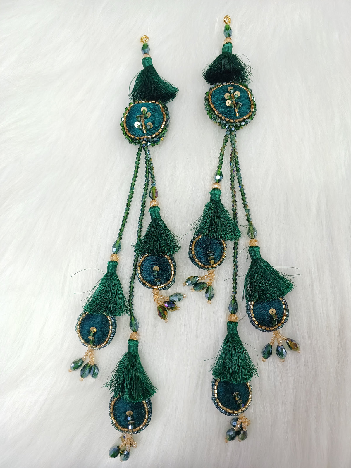 Bottle green lehenga latkan with cutdana and crystal handwork, featuring intricate embroidery and embellishments.