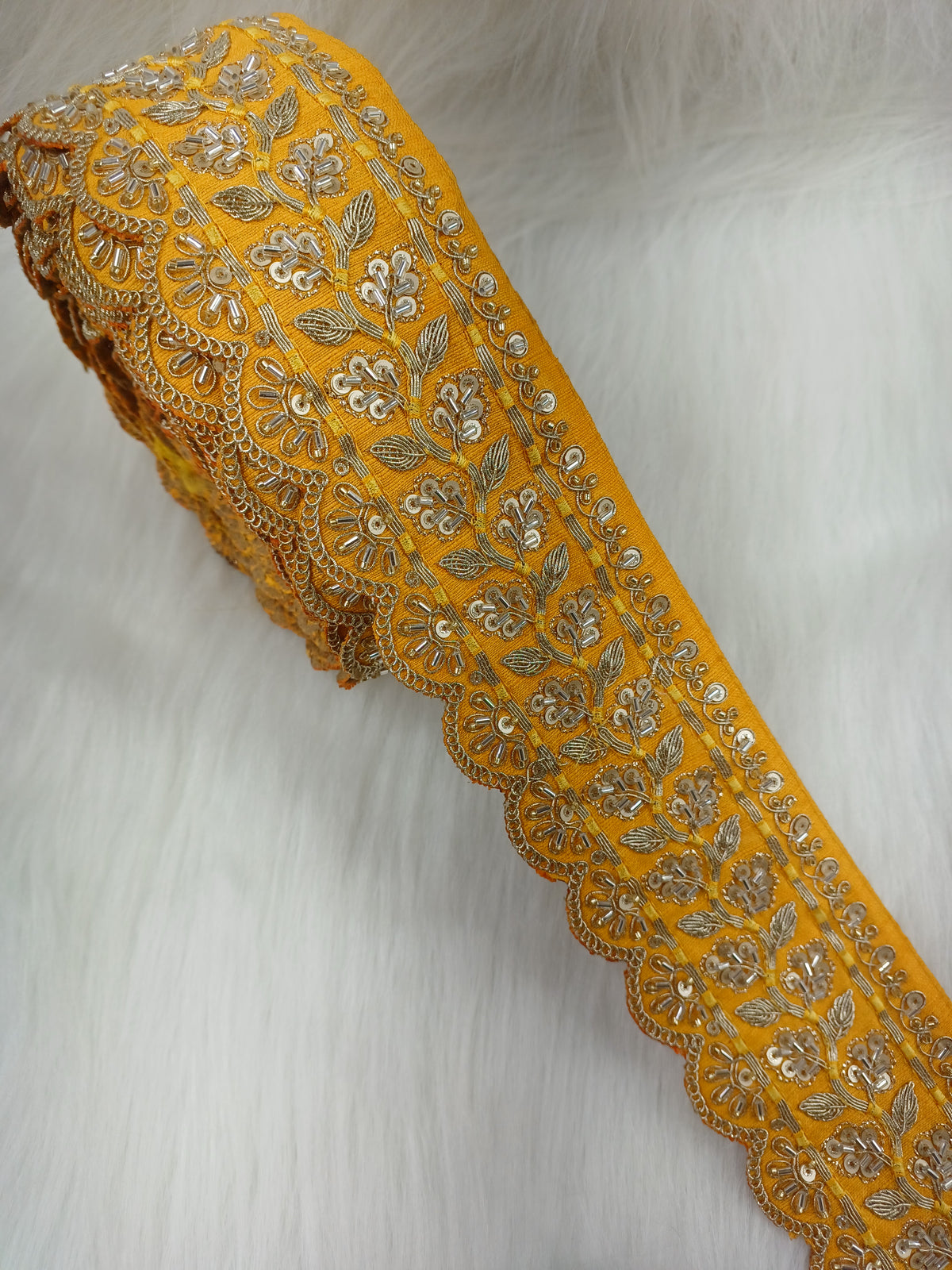 Yellow lace with intricate cutdana and jari handwork, detailed close-up of Lauce-Hut's elegant lace fabric.