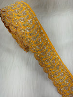 Yellow lace with intricate cutdana and jari handwork, detailed close-up of Lauce-Hut's elegant lace fabric.