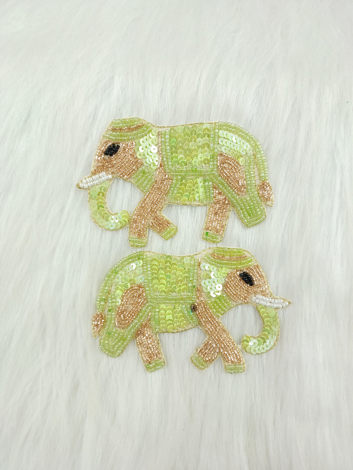Light green Zardosi poth and sequence handwork with elephant patch on fabric, showcasing intricate embroidery and detail.