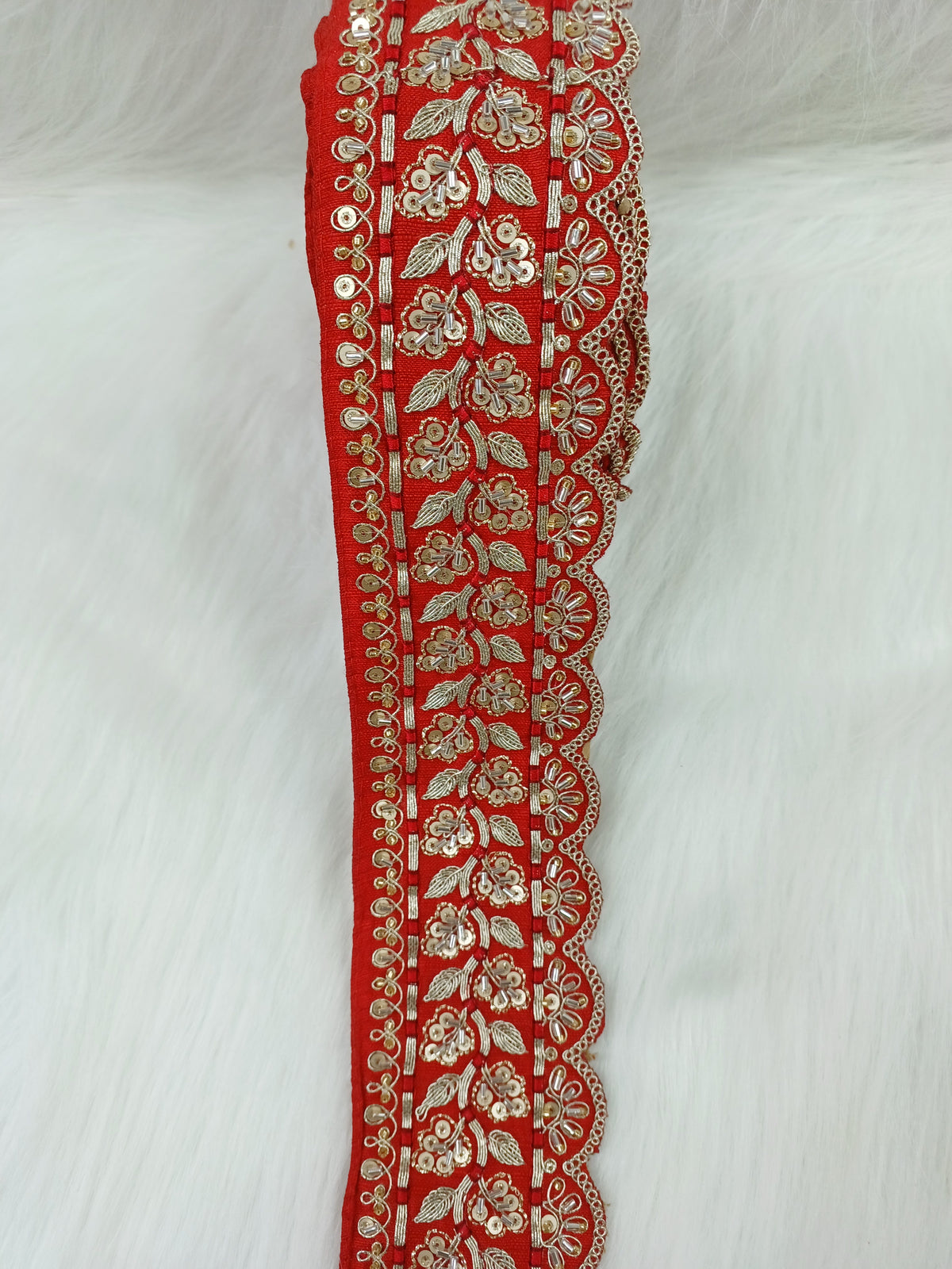 Red lace with intricate cutdana and jari handwork, showcasing detailed embroidery and delicate craftsmanship by Lauce-Hut.