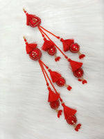 Red lehenga with intricate cutdana and crystal handwork, featuring decorative latkan for traditional ethnic wear.