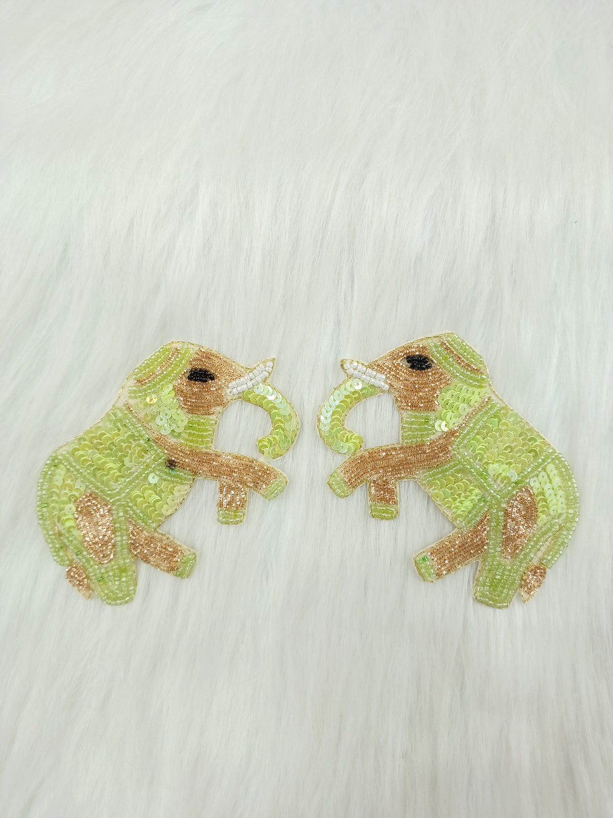 Light green elephant patch with Zardosi, bead, and sequins handwork on fabric, showcasing intricate embroidery and detailed embellishments.