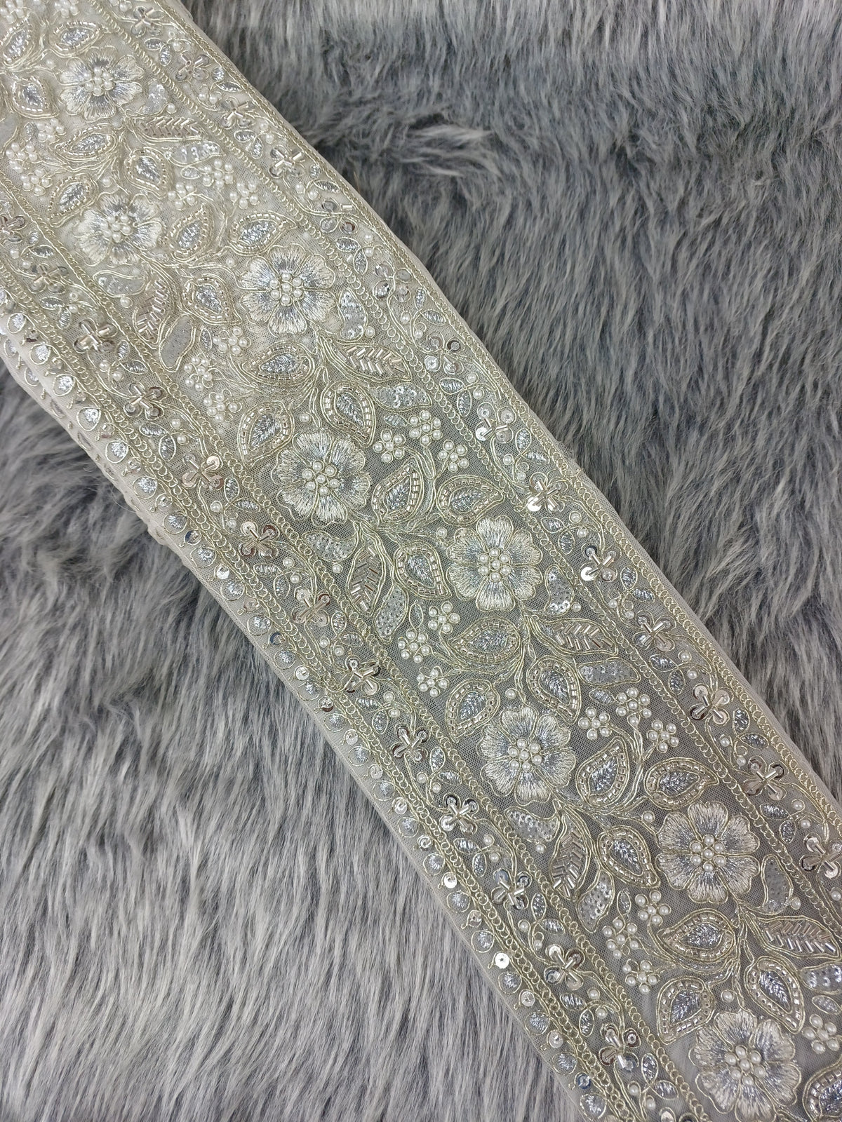 Silver lace with intricate cutdana and moti handwork, detailed close-up of Lace Hut's elegant silver embroidered lace.