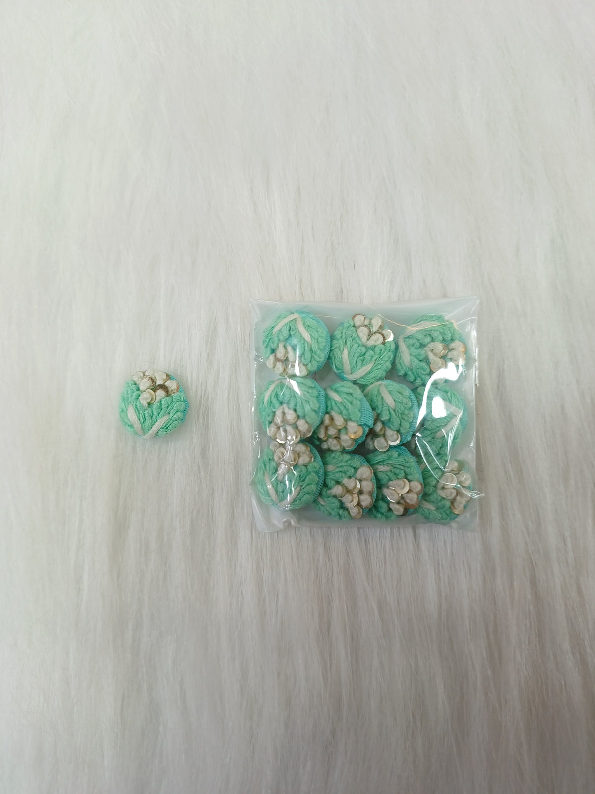 Sea green crochet handwork button from Lace Hut, featuring intricate design and a round shape with a glossy finish.
