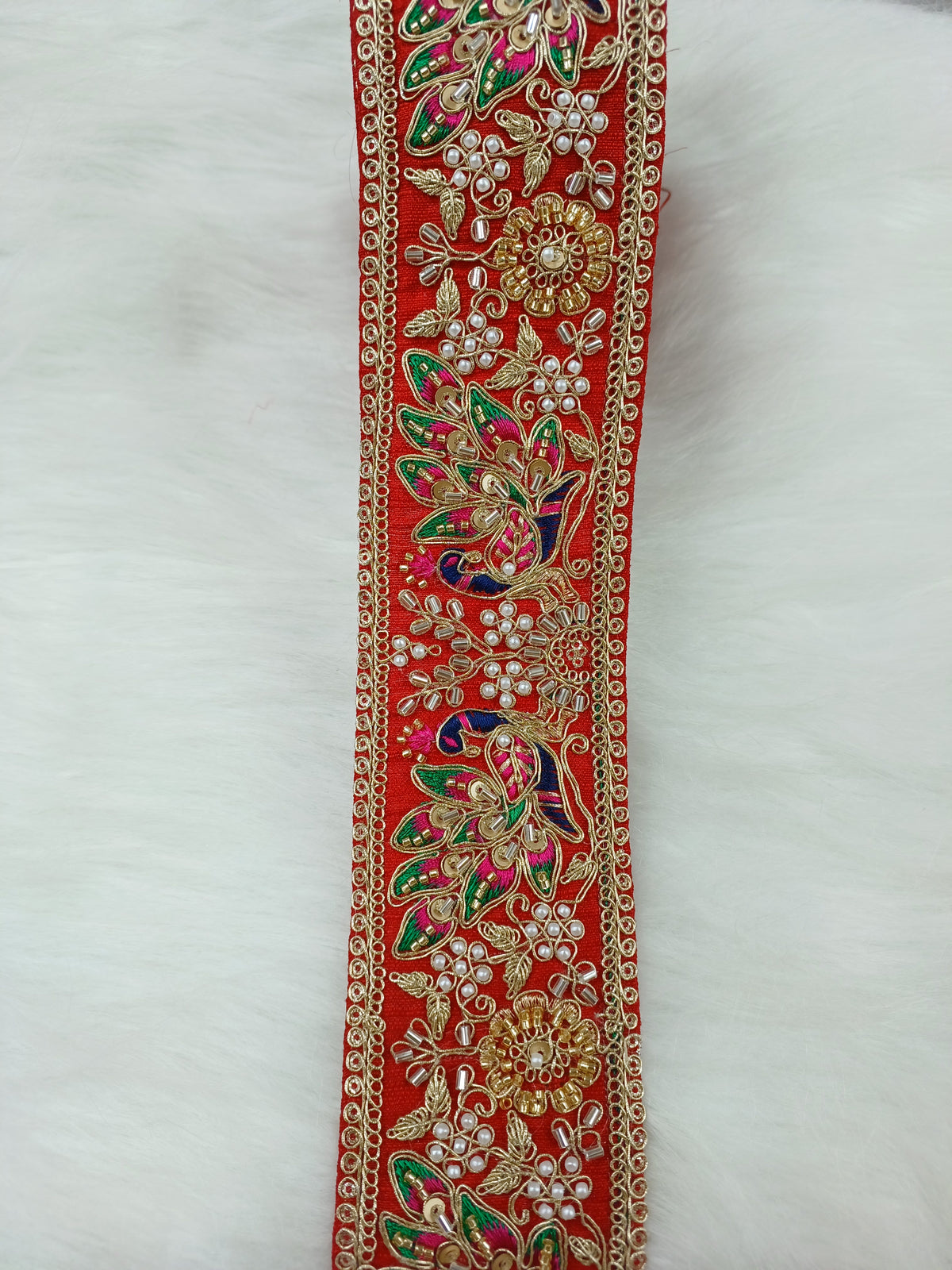 Peacock design lace with Cutdana and moti handwork on red base, vibrant multi-color floral embroidery, intricate and decorative.