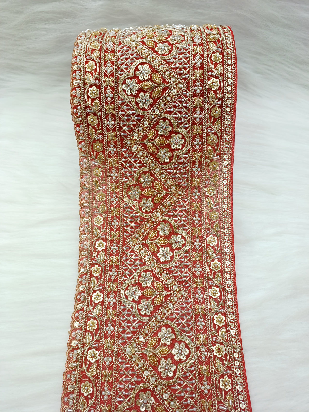 Red lace with cutdana and moti handwork on net base from Lace Hut, showcasing intricate embroidery and detailed design.