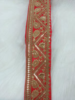Red Aari work lace fabric from Lauce-Hut featuring intricate embroidery and delicate lace pattern.