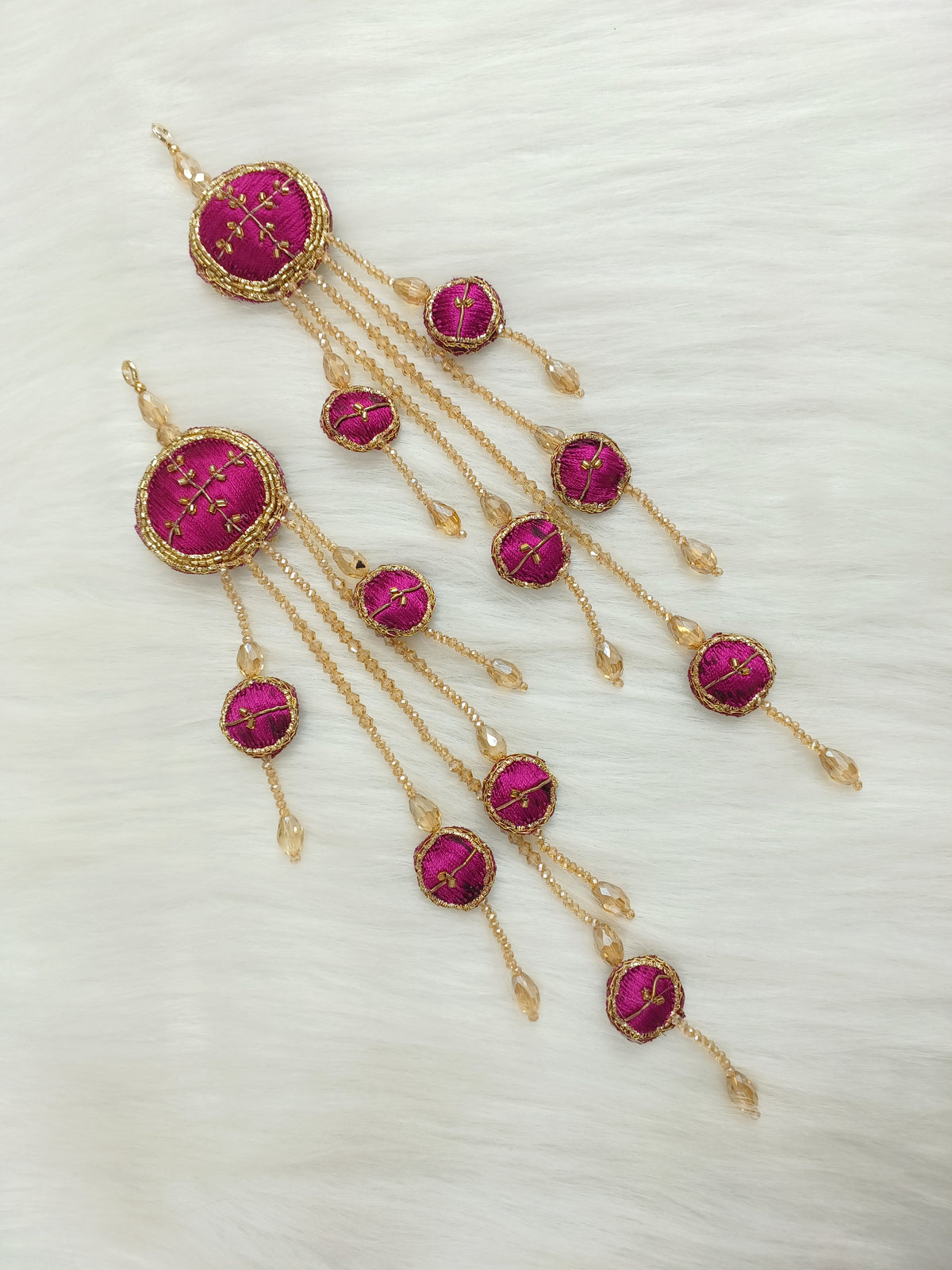Magenta Zardosi, cutdana, and crystal handwork lehenga latkan with intricate embroidery and hanging embellishments.