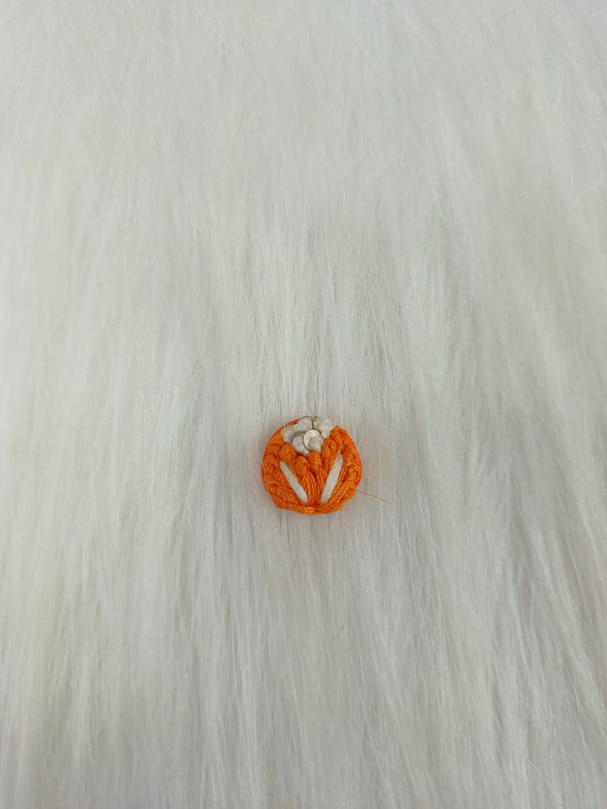 Orange crochet handwork button by Lace Hut featuring intricate design and a single prominent button for sewing or embellishments.