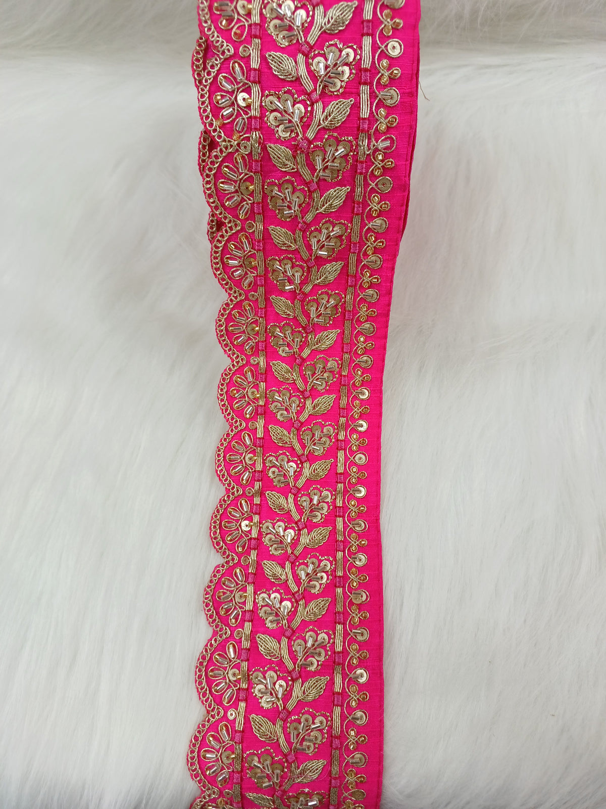 Rani pink lace with cutdana and jari handwork, detailed lace fabric from Lauce-Hut, close-up of intricate embroidery and delicate design.