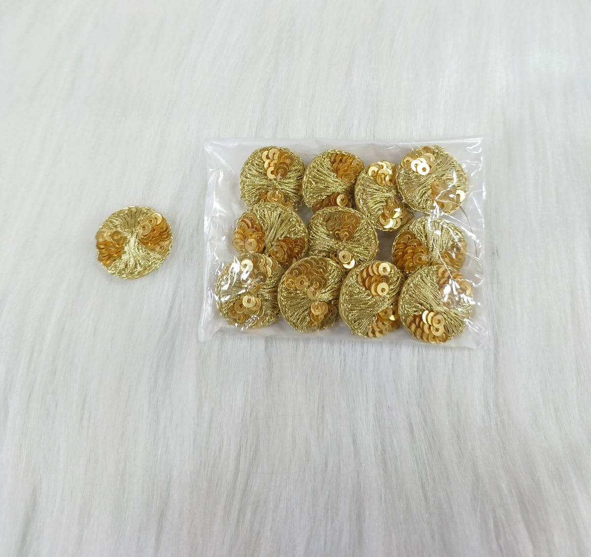 Bright golden Jari and sequined button from Lace Hut, showcasing intricate design and shiny decorative details.
