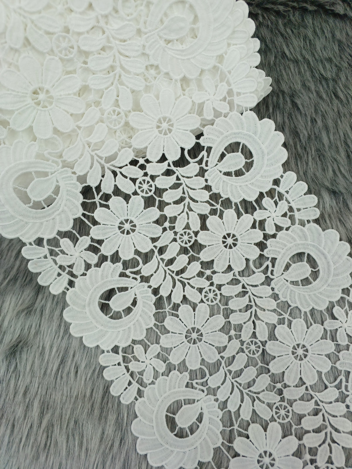 Close-up of intricate flower cut work cotton lace fabric from Xyz, showcasing detailed floral patterns and delicate craftsmanship.