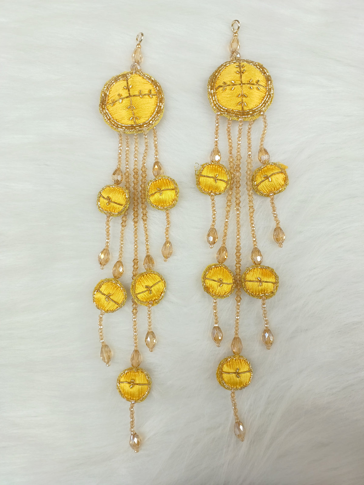 Yellow Zardosi cutdana and crystal handwork latkan with intricate embroidery and decorative beads.